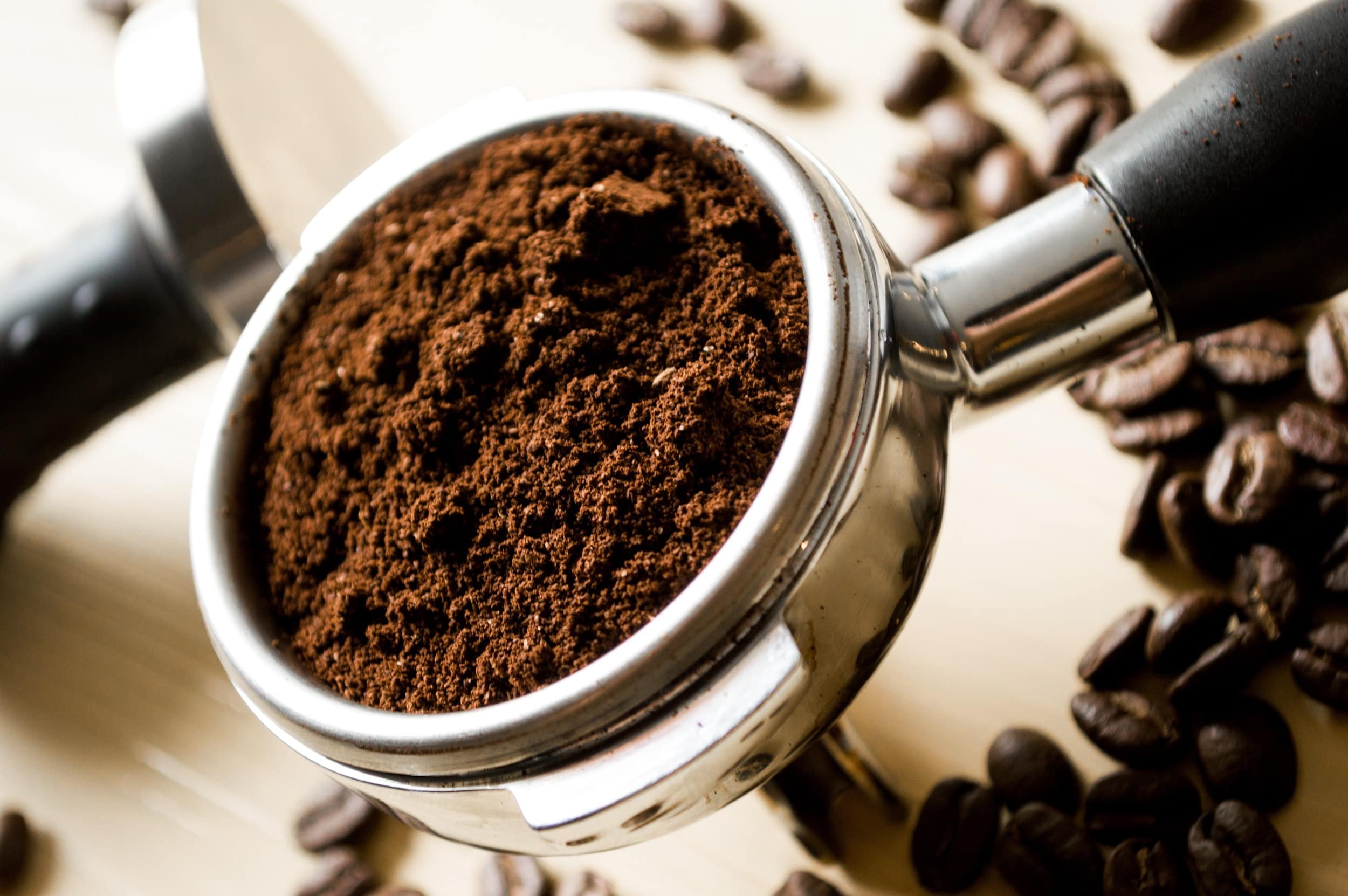 close-up of an espresso portafilter filled with coffee grounds