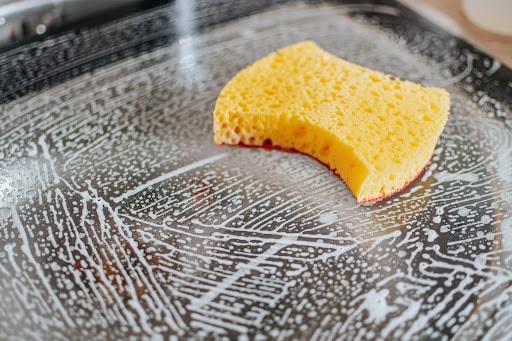 soapy sponge used to clean a stovetop