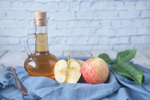 fresh cut apple beside apple cider vinegar